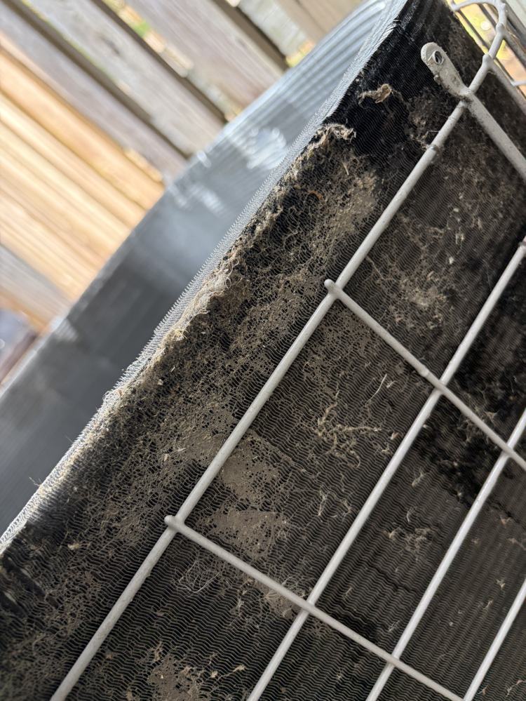 Close-up of dirt and debris embedded in the condenser coil